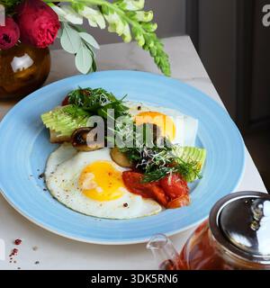 le chef a préparé des œufs ensoleillés avec de la laitue grillée et des champignons Banque D'Images