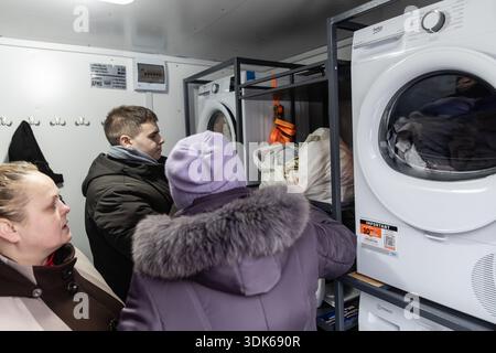 KIEV, UKRAINE - 29 janvier 2026 : des civils utilisent des machines à laver à l'intérieur d'une unité de blanchisserie mobile dans un point de solidarité à Kiev, dans un contexte de pénuries d'énergie causées par des grèves d'infrastructures. Banque D'Images