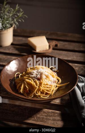 Spaghetti carbonara sur une plaque brune sur une table rustique. Banque D'Images