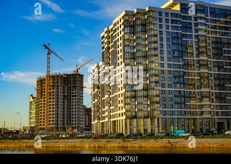 Développement urbain moderne avec de nouveaux bâtiments et grues de construction au coucher du soleil à St.Petersburg, Russie Banque D'Images