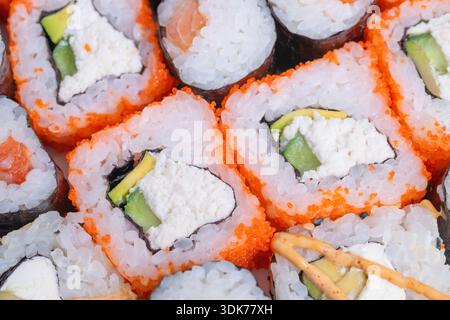 Assortiment de sushis avec garnitures vibrantes pour les fêtes. Sélection élégante de sushis avec des rouleaux assortis et des garnitures colorées pour les occasions spéciales Banque D'Images