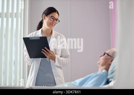 Jeune adulte femme médecin consultant patient homme senior Banque D'Images