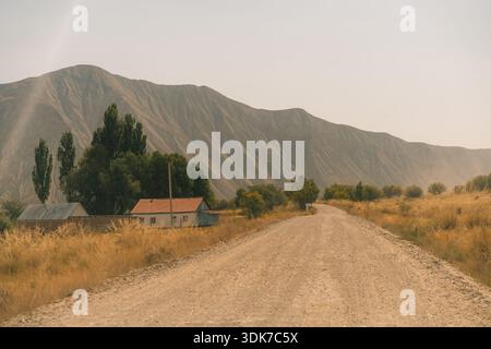 Un chemin de terre traversant un paysage aride et vallonné. Photo de haute qualité Banque D'Images
