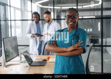 La femme en lunettes est debout. Les médecins travaillent dans le bureau. Banque D'Images