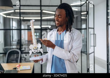 Man Doctor montre le modèle de la colonne vertébrale humaine. Banque D'Images