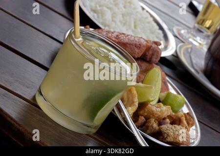Caipirinha, la célèbre boisson brésilienne, avec des plats d'accompagnement de feijoada, plat traditionnel de la cuisine brésilienne Banque D'Images