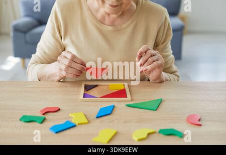 Femme âgée résolvant un puzzle géométrique pour la thérapie de la démence et l'entraînement cérébral Banque D'Images