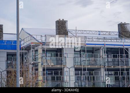 Immeuble d'appartements en rénovation avec échafaudage et lumière d'hiver montrant l'avancement de la construction idéal pour le développement immobilier de logements et reno Banque D'Images