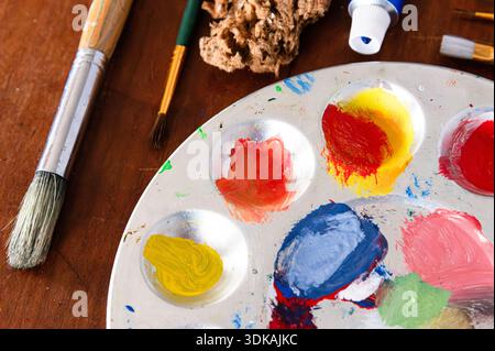 Vue de dessus d'une palette de peinture et de fournitures de peinture, y compris les pinceaux Banque D'Images
