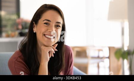 Portrait de femme heureuse assise sur un canapé dans le salon Banque D'Images