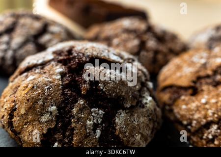 Biscuits froissés au chocolat faits maison enrobés de sucre en poudre sur une planche d'ardoise Banque D'Images