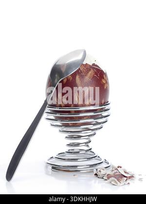 Oeufs à la coque avec des oeufs de Pâques ornement-shell dans un stand en spirale avec tee-spoon prêt pour le petit-déjeuner tourné sur fond blanc Banque D'Images