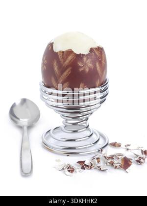 Oeufs à la coque avec des oeufs de Pâques ornement-shell dans un stand en spirale avec cuillère prêt pour le petit-déjeuner tourné sur fond blanc Banque D'Images