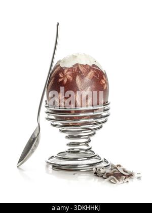 Oeufs à la coque avec des oeufs de Pâques ornement-shell dans un stand en spirale avec tee-spoon prêt pour le petit-déjeuner tourné sur fond blanc Banque D'Images