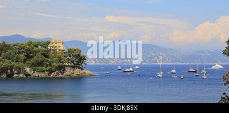 Une vue de la vieille maison en pierre parmi les arbres sur une falaise faisant saillie dans la baie de Portofino sur la mer Méditerranée en Italie Banque D'Images