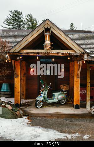 Une scène de vacances d'un cyclomoteur dans la porte d'un bâtiment de cabane en bois sur Dec. 26, 2025 dans le nord du Michigan. Banque D'Images