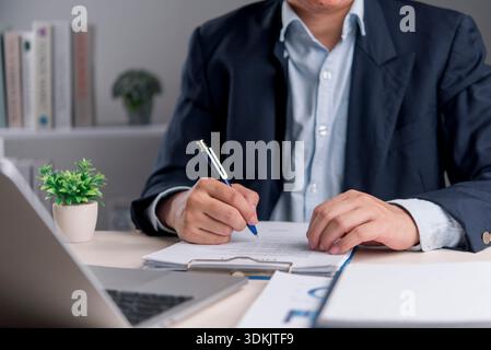 Signature, document Manager écrit sur le contrat au bureau moderne pour confirmer les termes et l'approbation, l'organisation des documents juridiques et la conformité avec PEN besi Banque D'Images