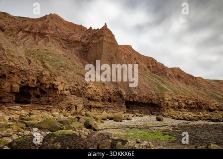 Pinacle de forme étrange sculpté par le vent et la pluie dans les falaises brunes douces de Filey Beach, North Yorkshire, Angleterre. Banque D'Images
