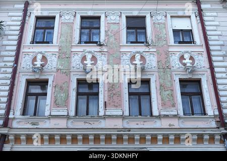 Façade de maison délabrée avec des bustes de la mythologie grecque, Czernowicz, Ukraine Banque D'Images