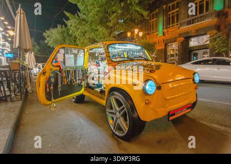 Voiture vintage orange originale affichée dans une rue la nuit à Erevan, Arménie. Banque D'Images