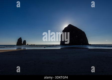 États-Unis, Oregon, coucher de soleil derrière le rocher de meule de foin sur Cannon Beach Banque D'Images