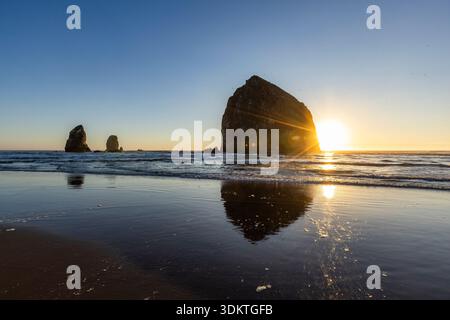 États-Unis, Oregon, coucher de soleil derrière le rocher de meule de foin sur Cannon Beach Banque D'Images