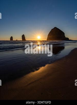 États-Unis, Oregon, coucher de soleil derrière le rocher de meule de foin sur Cannon Beach Banque D'Images