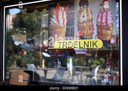 Vitrine présentant des pâtisseries Trdelnik accompagnées de crème glacée, reflétant les places en plein air d'un magasin de Tbilissi (Géorgie) le 29 janvier 2026 Banque D'Images