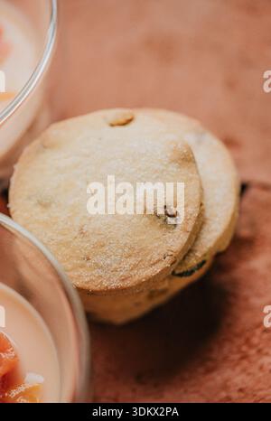 Un biscuit est assis sur une table à côté d'un verre de lait. Le biscuit est recouvert de sucre et semble délicieux Banque D'Images