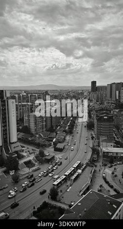 Vue panoramique d'un paysage urbain en noir et blanc, rues animées entre gratte-ciel Banque D'Images