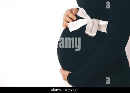 Femme enceinte en robe noire Holding Belly closeup Banque D'Images