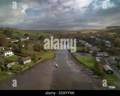 Vue aérienne de la rivière et du village rural à Cornwall, Angleterre. Photographie aérienne à haute résolution montrant une rivière serpentant à travers un village rural Banque D'Images