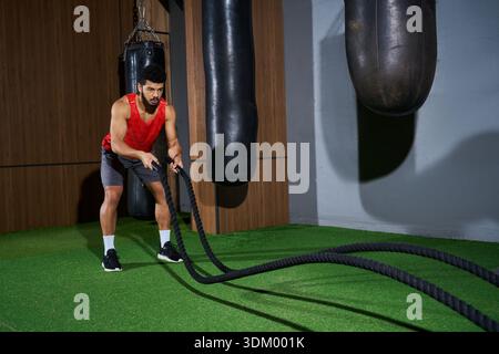 Un jeune homme afro-américain renforce sa forme physique avec un entraînement dédié dans le gymnase. Banque D'Images