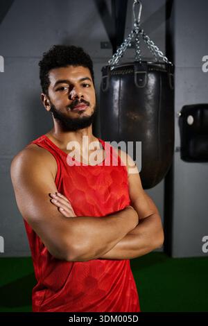 Un jeune homme afro-américain avec une barbe se tient confiant dans le gymnase prêt à s'entraîner. Banque D'Images