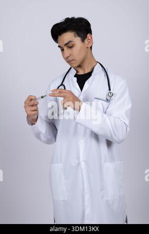 Médecin masculin en manteau blanc préparant la seringue médicale Banque D'Images