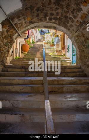 Une arche médiévale historique en pierre à Monreale, Sicile, Italie. Un passage du XIVe au XVIe siècle mène à une route plus élevée via un ensemble de marches bien usées. Banque D'Images