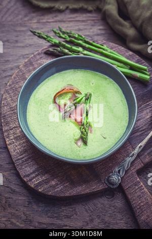 Soupe crémeuse aux asperges et aux épinards dans une assiette en céramique Banque D'Images