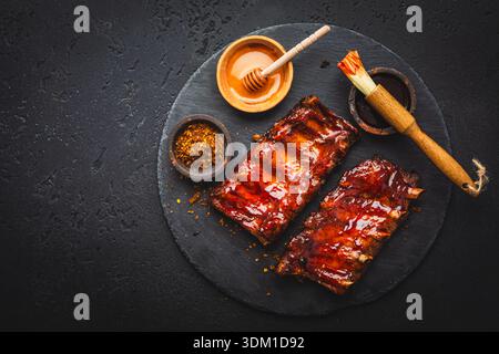 Barbecue porc côtes de rechange avec épices et miel comme vue de dessus sur une vieille planche rustique avec espace de copie Banque D'Images