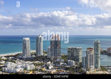 Vue aérienne des gratte-ciels étincelants rencontre l'océan turquoise, encadré par les rivages sablonneux de South Beach, Miami Beach, Floride, États-Unis. Banque D'Images