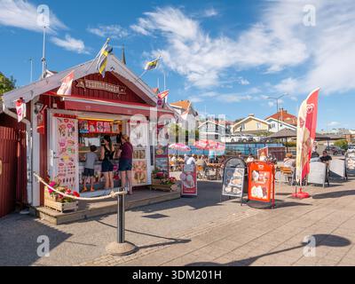 Kiosque de crème glacée avec comptoir de collations et places assises en plein air le long de Strandpromenaden à Lysekil, Bohuslän, côte ouest suédoise, les gens commandent de la crème glacée Banque D'Images
