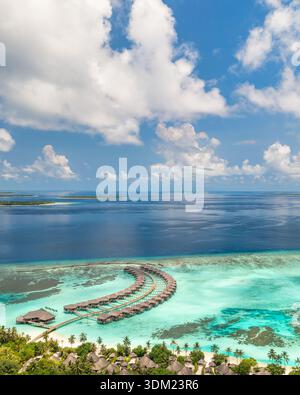 Immersive Maldives aériennes villas sur l'eau plus large radiant océan turquoise magnifique paradis exotique littoral luxe destination papier peint vertical Banque D'Images