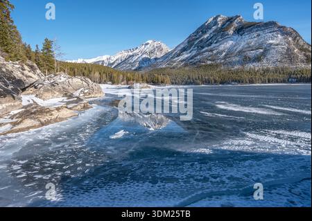 Réflexions dans le lac Minnewanka gelé, dans le parc national Banff, Alberta, Canada Banque D'Images