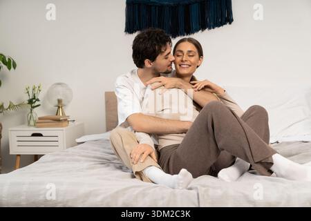 Jeune couple profite de moments affectueux ensemble dans leur maison élégante, entouré de confort. Banque D'Images