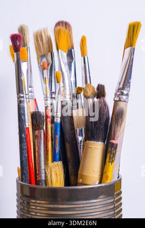 Une collection de divers pinceaux est montrée debout sur un fond clair. Ces pinceaux sont utilisés pour la peinture et l'activité artistique Banque D'Images