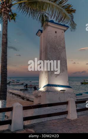 Le phare penché de Puerto Morelos sur la plage pendant un coucher de soleil coloré. Banque D'Images