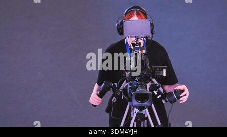 Professionnel de la production multimédia exploitant une caméra vidéo pour la diffusion ou le tournage Banque D'Images