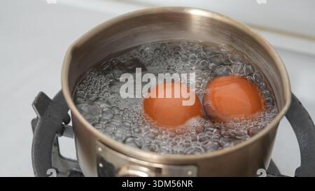Œufs bouillants avec casserole en acier inoxydable pour le petit déjeuner Banque D'Images
