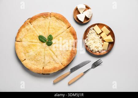 Pizza savoureuse avec du fromage et des couverts sur fond clair Banque D'Images