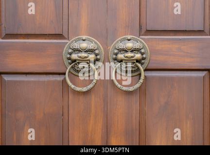 Porte en bois classique chinoise. Bâtiments de style chinois traditionnel. Ancienne poignée de porte dradon vintage. Gros plan Banque D'Images