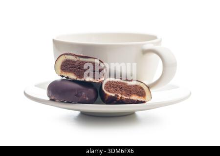 Truffes au chocolat noir en forme de grains de café et tasse de café isolé sur un fond blanc. Banque D'Images